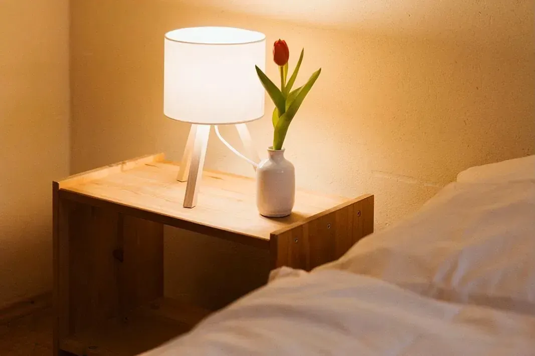 Nachttisch mit warmem Licht – Ruhe im Zimmer während des Retreats